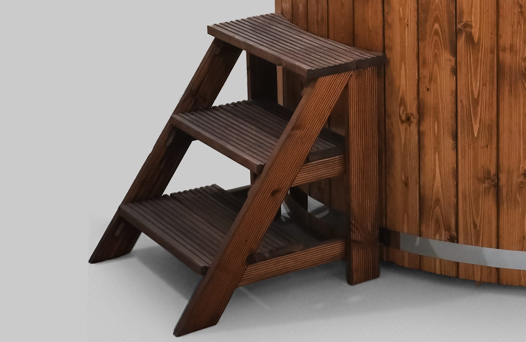 Holz-Einstiegstreppe mit drei Stufen, aus dunklem Holz gefertigt, neben einem Feuerbad Hot Tub SOPHIA